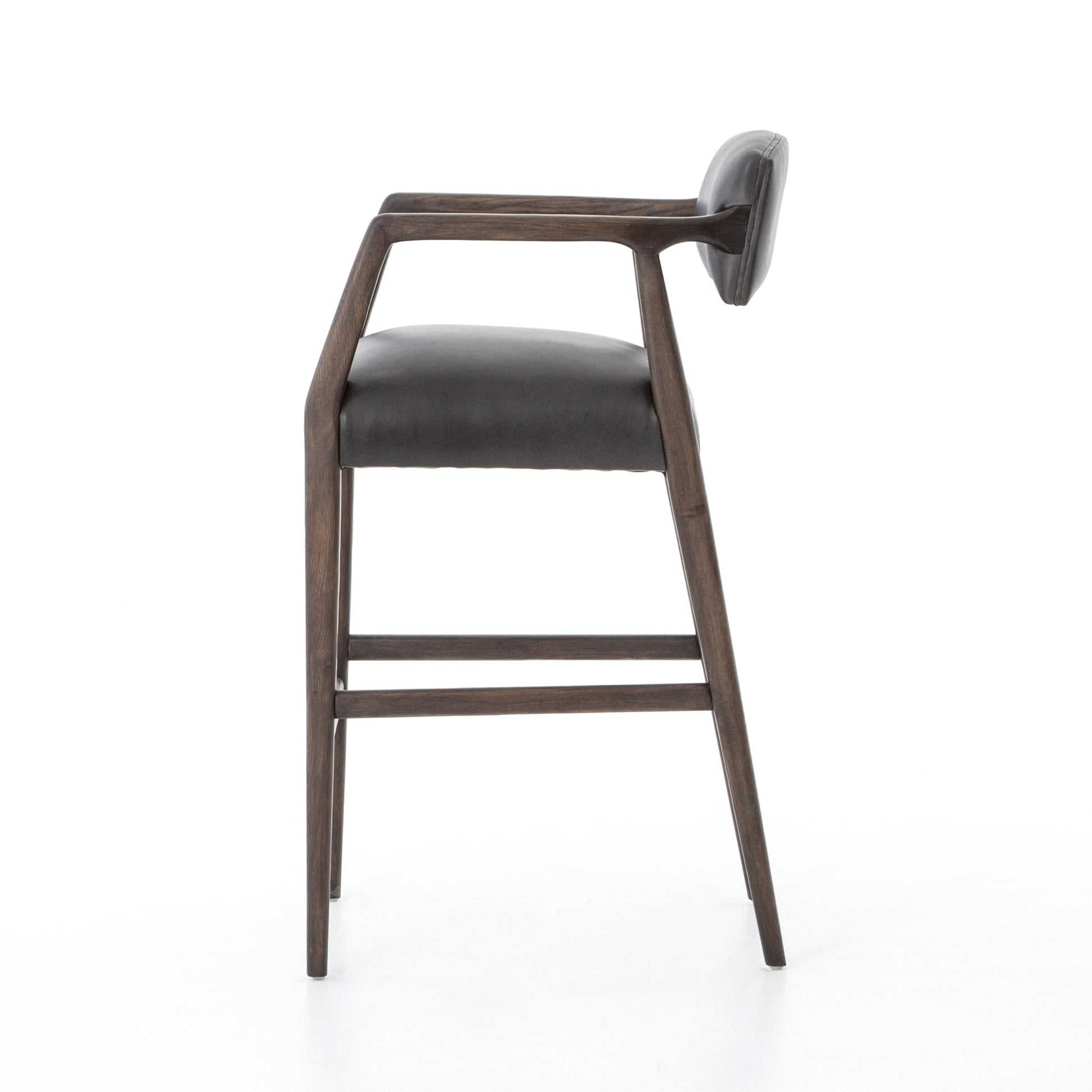 The Tyler Bar + Counter Stool - Ebony makes counter seating stylish with an angular, dark and smoky birch frame, a deep seat, and a striking, low-slung back. The stool is comfortable for long dinners and conversations with a covered black, top-grain leather seat and back.