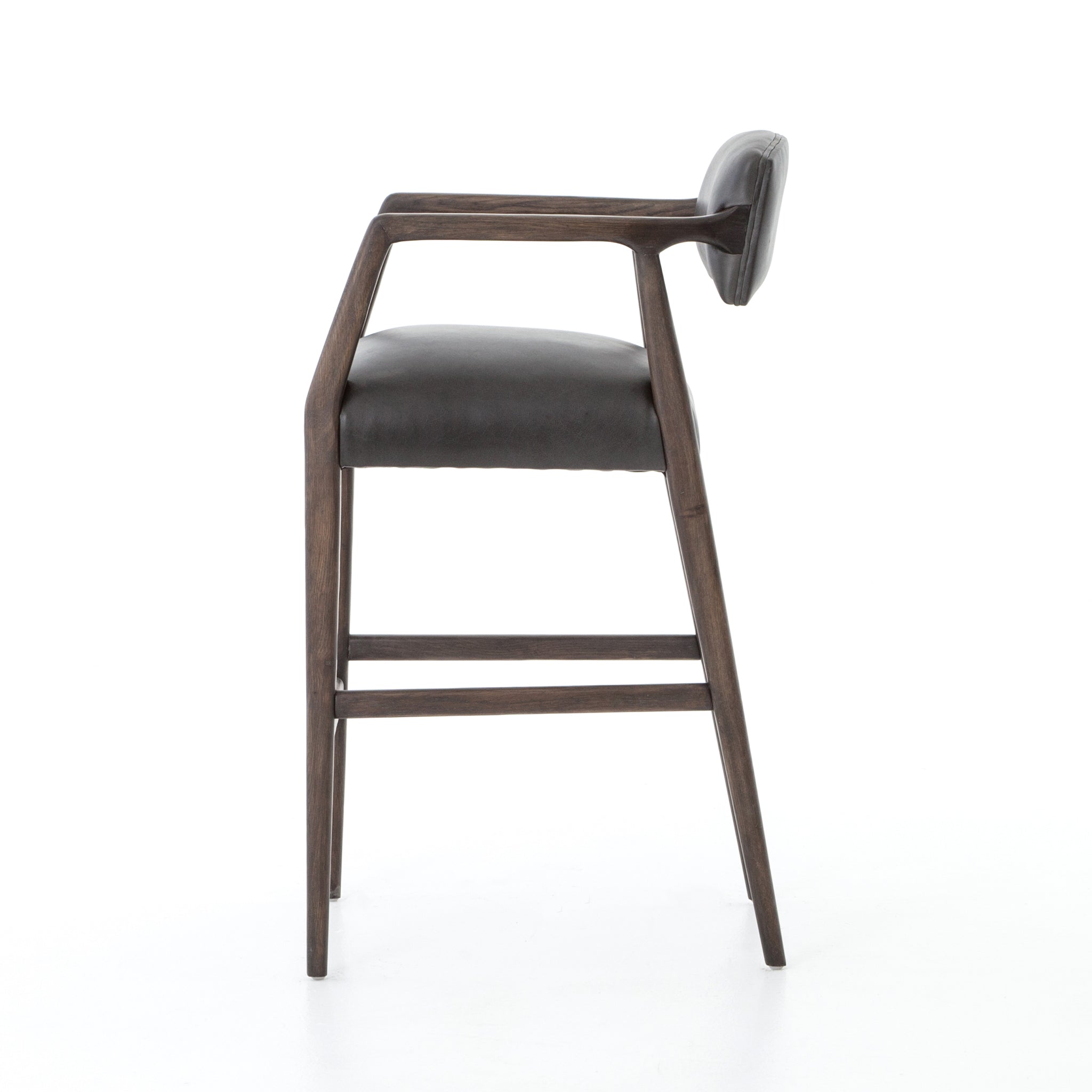 The Tyler Bar + Counter Stool - Ebony makes counter seating stylish with an angular, dark and smoky birch frame, a deep seat, and a striking, low-slung back. The stool is comfortable for long dinners and conversations with a covered black, top-grain leather seat and back.