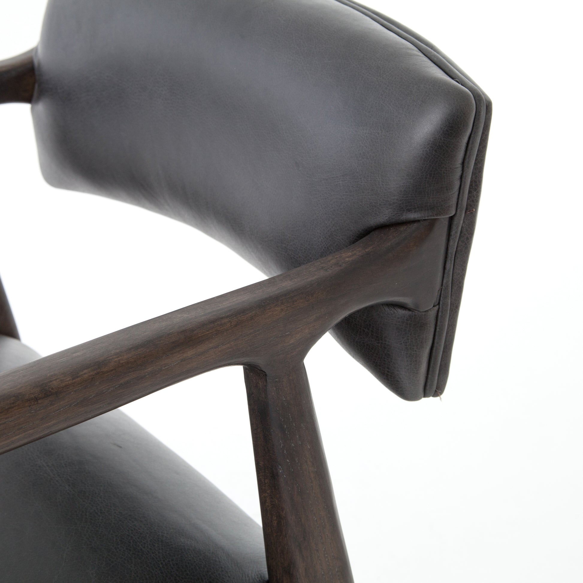 The Tyler Bar + Counter Stool - Ebony makes counter seating stylish with an angular, dark and smoky birch frame, a deep seat, and a striking, low-slung back. The stool is comfortable for long dinners and conversations with a covered black, top-grain leather seat and back.