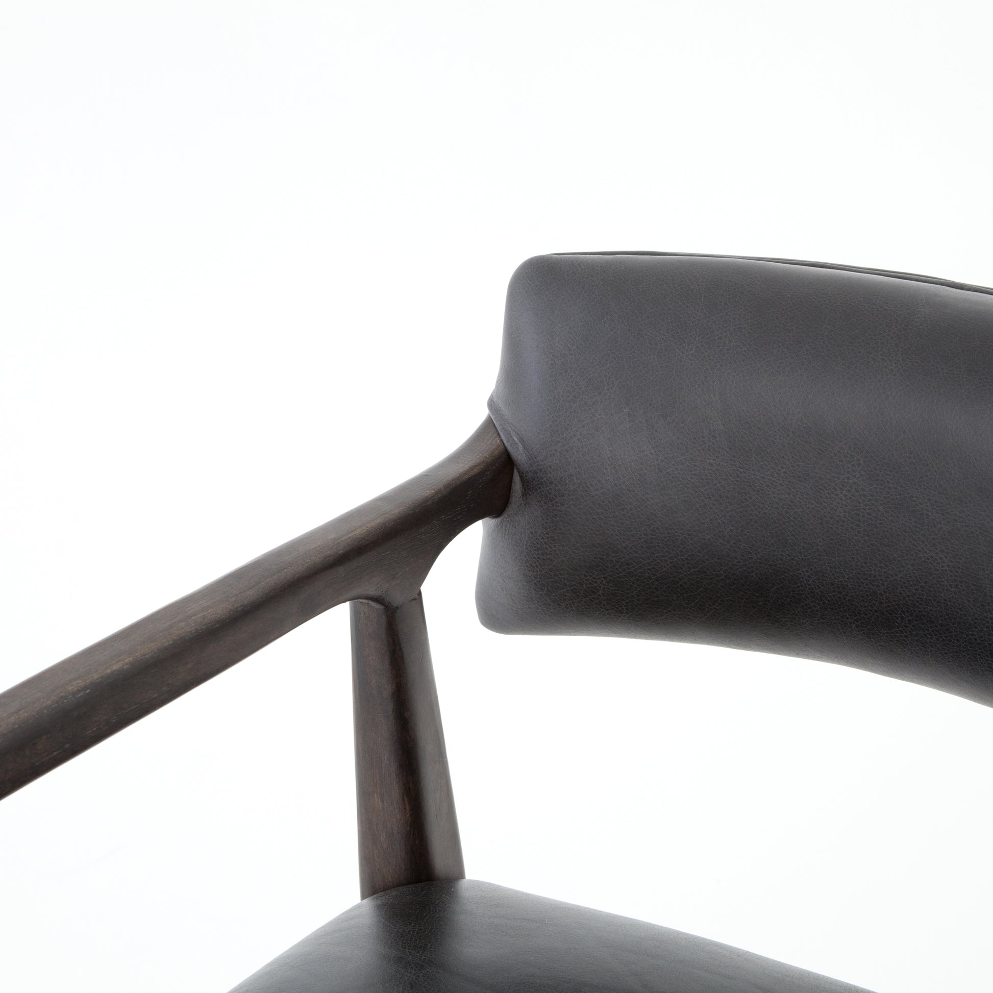 The Tyler Bar + Counter Stool - Ebony makes counter seating stylish with an angular, dark and smoky birch frame, a deep seat, and a striking, low-slung back. The stool is comfortable for long dinners and conversations with a covered black, top-grain leather seat and back.