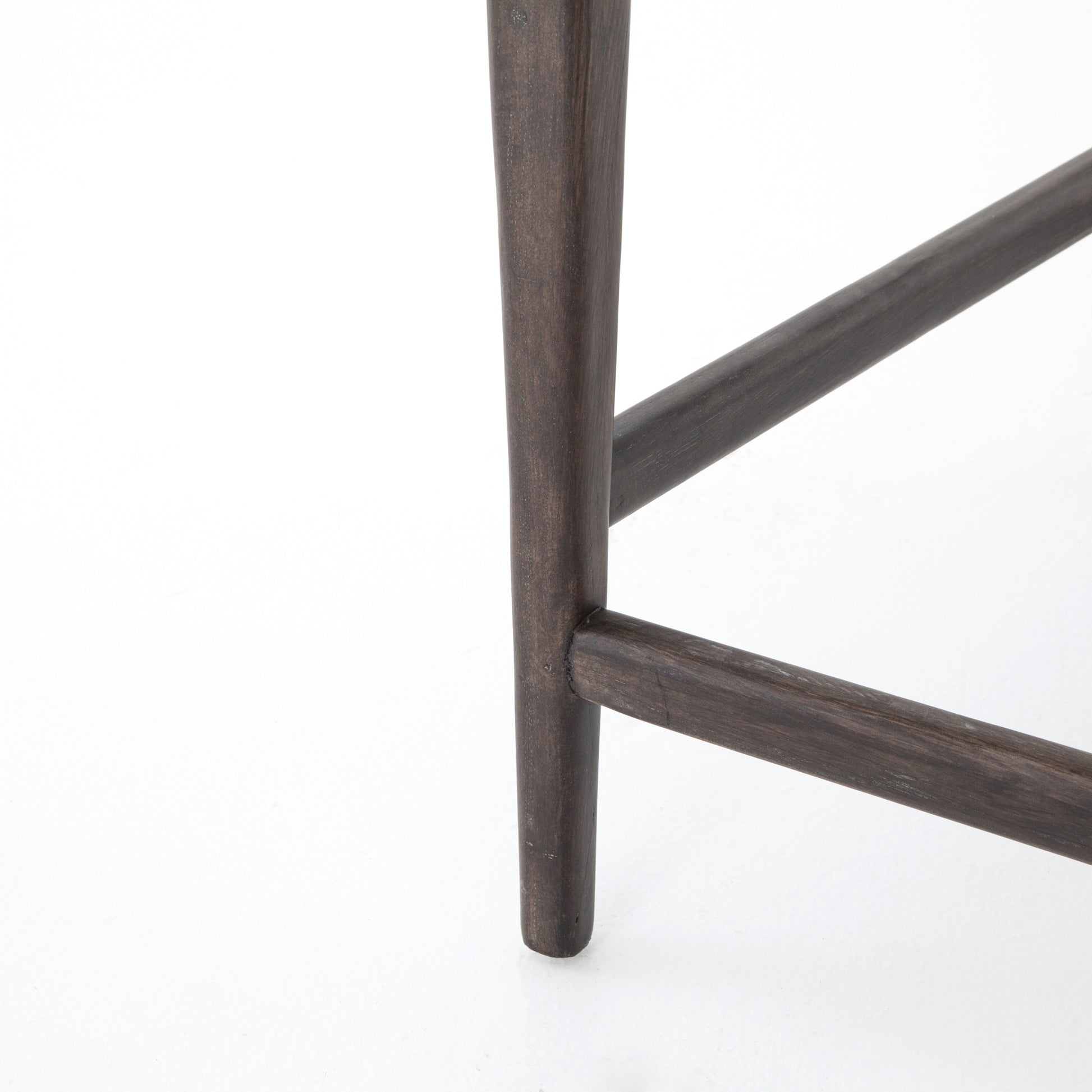 The Tyler Bar + Counter Stool - Ebony makes counter seating stylish with an angular, dark and smoky birch frame, a deep seat, and a striking, low-slung back. The stool is comfortable for long dinners and conversations with a covered black, top-grain leather seat and back.