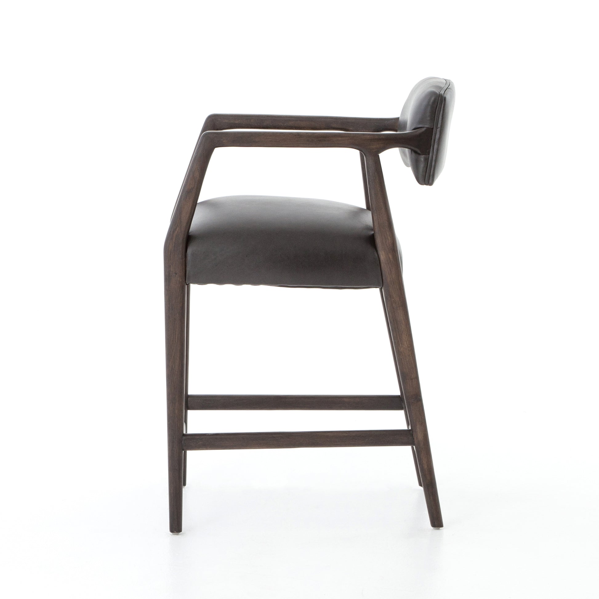 The Tyler Bar + Counter Stool - Ebony makes counter seating stylish with an angular, dark and smoky birch frame, a deep seat, and a striking, low-slung back. The stool is comfortable for long dinners and conversations with a covered black, top-grain leather seat and back.