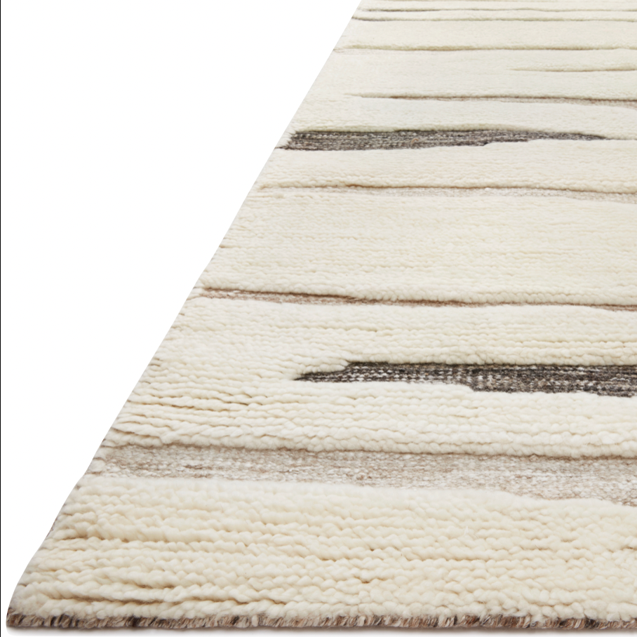 The Loloi Bennett Ivory / Bark Area Rug, or BEN-03, is hand-knotted of wool, viscose and polyester in India. Featuring a new carve like high-low pile, Bennett has an ivory base with abstract tonal designs. Plus, it's plush underfoot-- a great choice for your office, bedroom, or other medium traffic areas. 